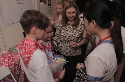 Visitors discuss the innovations with young inventors in IYIA 2018